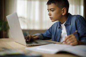 distance learning, Teenage boy using laptop for homework